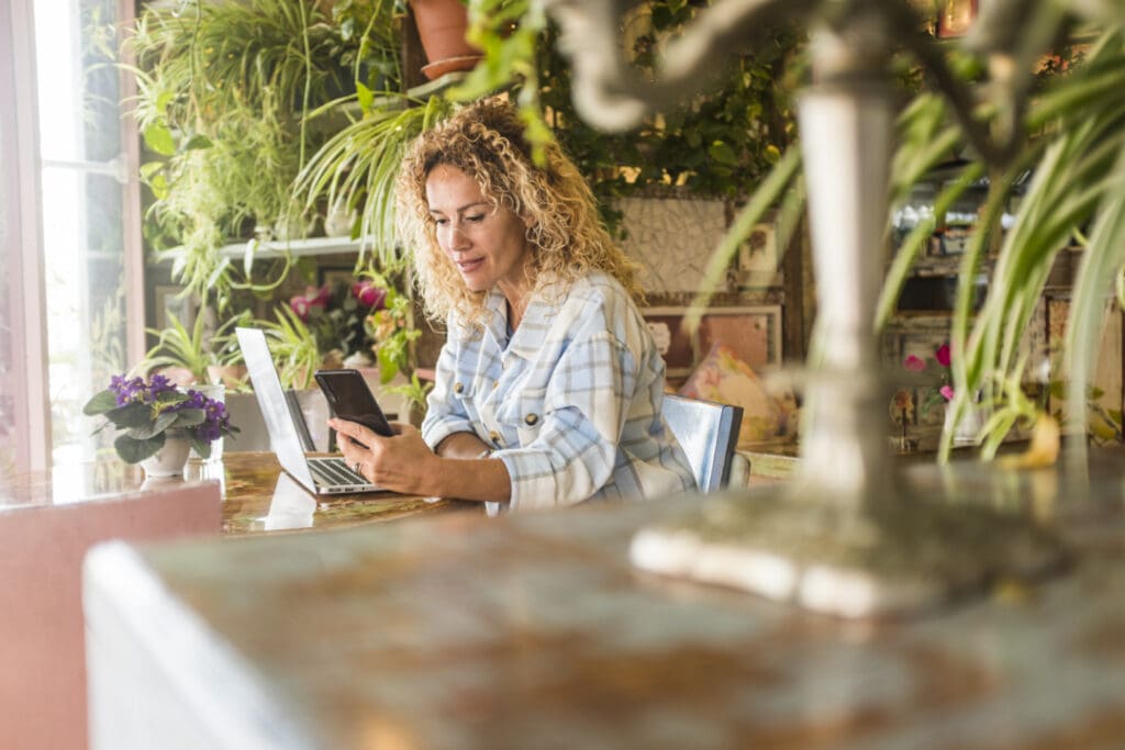 Small business owner checking their website on a laptop with a phone showing the same site beside it