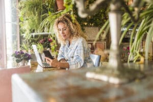 Small business owner checking their website on a laptop with a phone showing the same site beside it